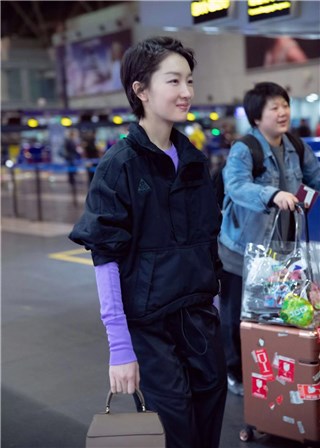 周冬雨黑色工装现身机场 紫色内搭明亮个性引人关注