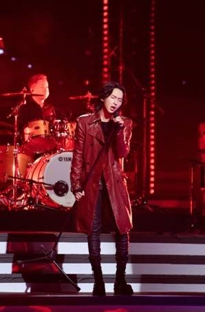 黑豹乐队主唱张淇穿红色皮质长风衣,沉浸在经验摇滚歌曲之中