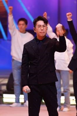 林晓峰唱《我们都是追梦人》,右手握拳高举眼神坚定看向前方