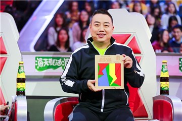 刘国梁憨厚的举着十四巧板