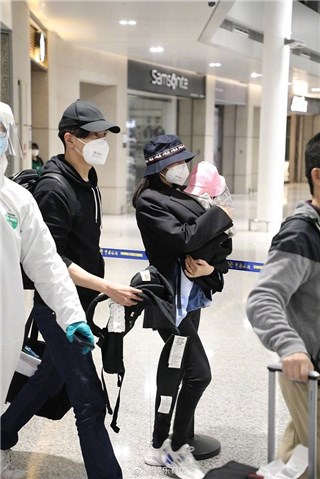 赵又廷一家三口同框现身机场   高圆圆用穿着的外套裹住女儿