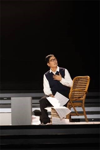郭晓东扮演的《歌唱祖国》词曲作者王莘坐在藤条椅上,隔空倾诉